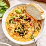 a bowl of creamy tomato soup with sausage, pasta, Parmesan cheese, and fresh basil, plus bread for dipping
