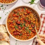 a large bowl of spanish-style lentil soup with chorizo and fresh herbs